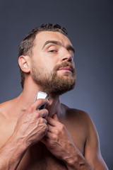 Cheerful bearded guy is caring of his appearance