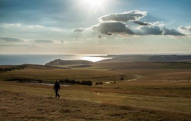 Mann zu FußLandschaft  Seven Sisters-Klippen UK bei Sonnenuntergang