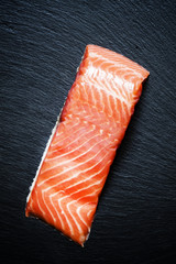 Fillet of salty salmon with spicy pepper and sea salt, top view