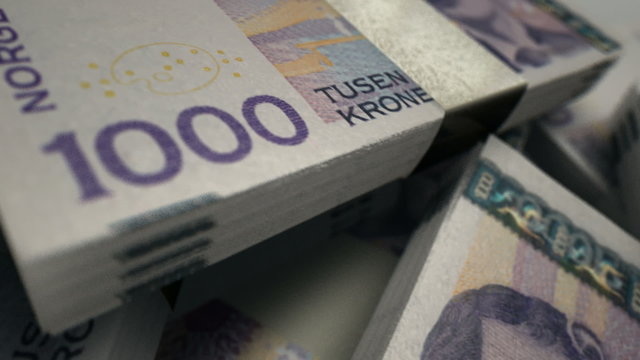 An extreme closeup pan across variously placed bundled wads of  Norwegian Krone banknotes