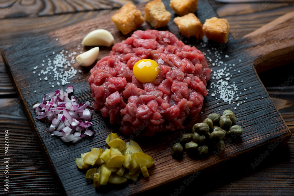 Wall mural Beef tartare with chopped onion, pickles, capers and croutons