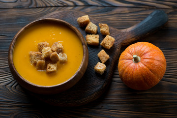 Pumpkin cream-soup with croutons, selective focus, studio shot