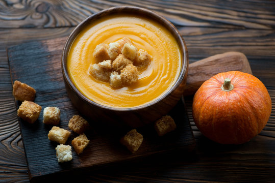 Freshly made pumpkin cream-soup with croutons, studio shot
