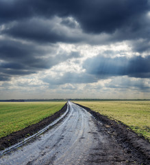 Naklejka premium dirty road to horizon and dramatic sky