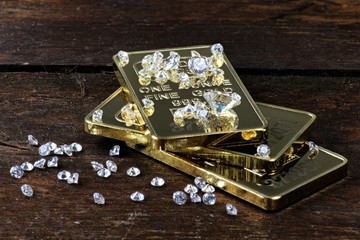 Goldbarren und geschliffene Diamanten auf rustikalem Holzhintergrund