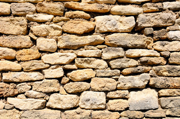 Old ramshackle stone wall in medieval french village.