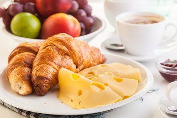 Croissants with cheese, fruits and coffee