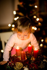 Child blowing advent wreath 