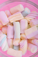 marshmallow candies of different colors in the glass on the background of pink. top view. entertainment for children in celebration.