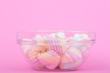 marshmallow candies of different colors in the glass on the background of pink. top view. entertainment for children in celebration.