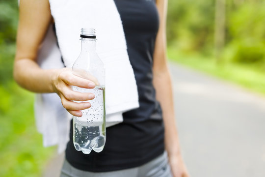 Woman Stands Outdoor And Drinks Water After Workout