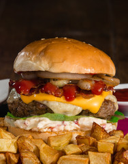 Large burger served with crispy baked potatoes