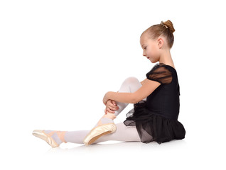 Little ballerina sitting on floor