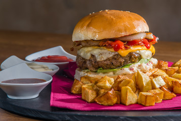 Large burger served with crispy baked potatoes