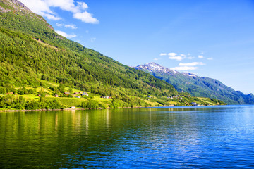 Meadows and village on Hardanger Fiord. Norway shore with view. Norway.