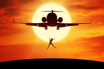Happy woman leaps on the hill under airplane