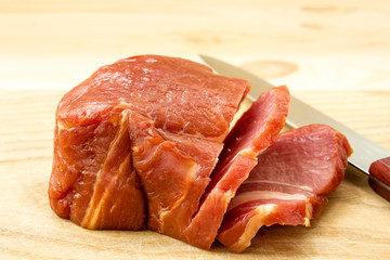 Sliced Meat on wooden background with knife