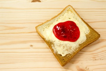 Toast with jam on wooden background