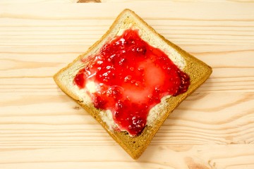 Toast with jam on wooden background