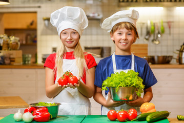 Happy smiling Chef boy and girl preparing healthy food at