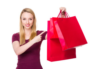 Caucasian woman with finger point to shopping bag