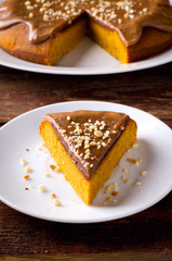 Pumpkin cake with caramel and peanuts on wooden table