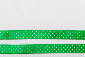 Dotted green blue ribbon frame on white cloth