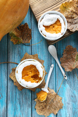 Tasty pumpkin pie in bowl on a blue wooden table