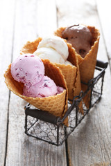 Waffle cones with ice cream on wooden table