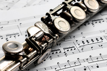 Old rusty silver flute on music notes