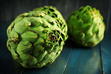 Fototapeta premium Artichokes on color wooden background