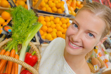 Woman showing basket of vegetables