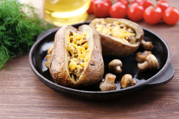 Fototapeta na wymiar Baked potatoes with cheese and mushrooms on table close up