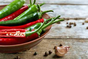 Hot peppers with spices on wooden table close up