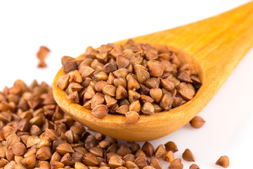 Uncooked buckwheat on wooden spoon