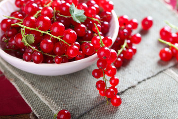 Fresh red currants in bowl on table close up