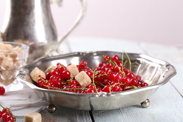 Fresh red currants with sugar on table close up