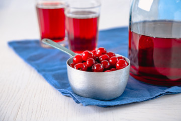 Sweet homemade cherry juice on table, on light background