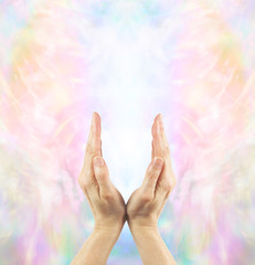 Channeling Angelic Healing Energy - Pair of female hands cupped upwards with a beautiful ethereal...