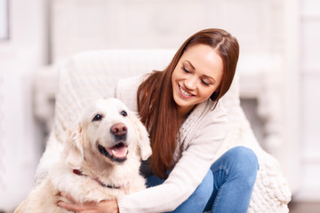Young girl patting her pet dog. 