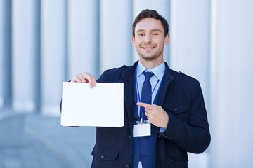 Smiling reporter points at sheet of paper.