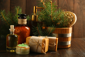 Essential oil of pine, handmade soap and cream with pine extract and spa treatments on wooden background