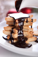 Christmas cookies with chocolate syrup on a white plate.