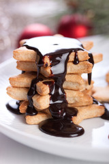 Christmas cookies with chocolate syrup aon a white plate.
