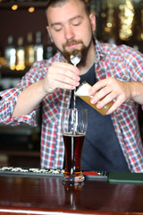 Bartender is pouring beer into glass