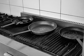 Frying pan on a cooker. Black and white photo.