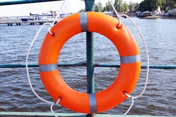 A life buoy hangs on the pier's handrail