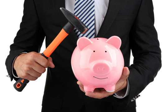 Man with a hammer going to break the piggy bank, close up