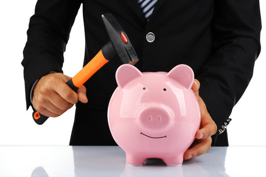 Man with a hammer going to break the piggy bank, close up