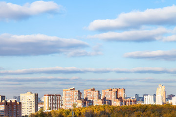 Fototapeta na wymiar blue sky with clouds over modern houses in autumn